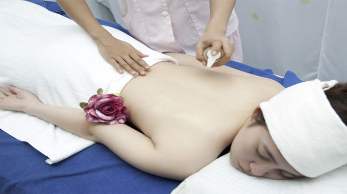 Kỹ thuật viên thực hiện ấn huyệt trị liệu đau vai gáy TPHCM chuẩn xác